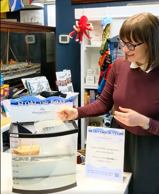 Brittany Vis pouring water into the milestone tank to reach the $15,000 marker.